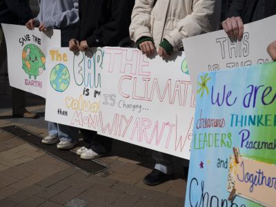 image of hands holding climate action signs