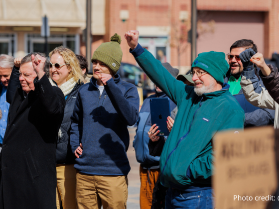 The crowd at the rally on 2/22/2025 holding up their fists and cheering. Photo credit: @elmanstudio